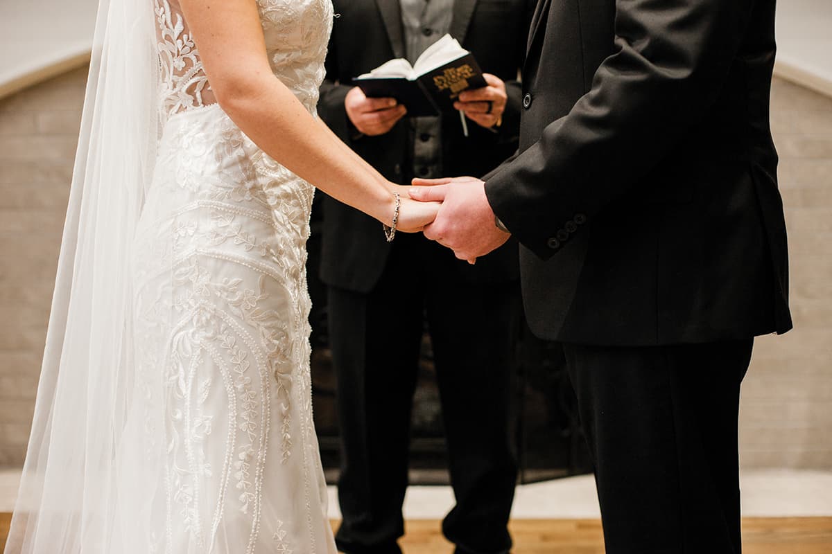 Ashlyn + Brock Harrell wedding Oak Meadow holding hands ceremony