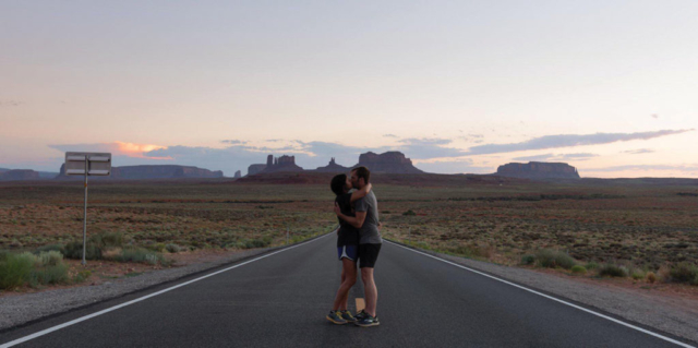 thomas + megan engaged kissing highway arizona desert