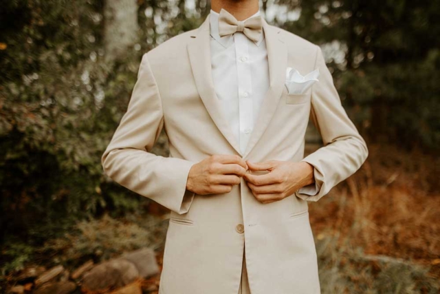 Kaylan-Chris-wedding closeup groom cream suit with bowtie