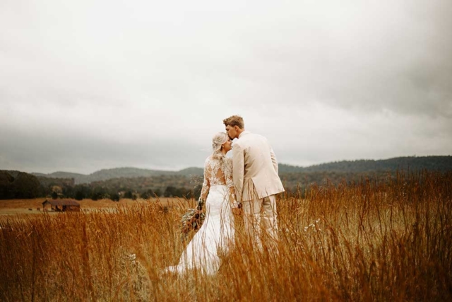 Kaylan-Chris-wedding couple portrait kissing in country field