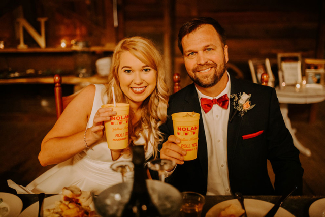 Mary-Catherine and Christopher wedding smiling couple with souvenir plastic cup Roll Tide