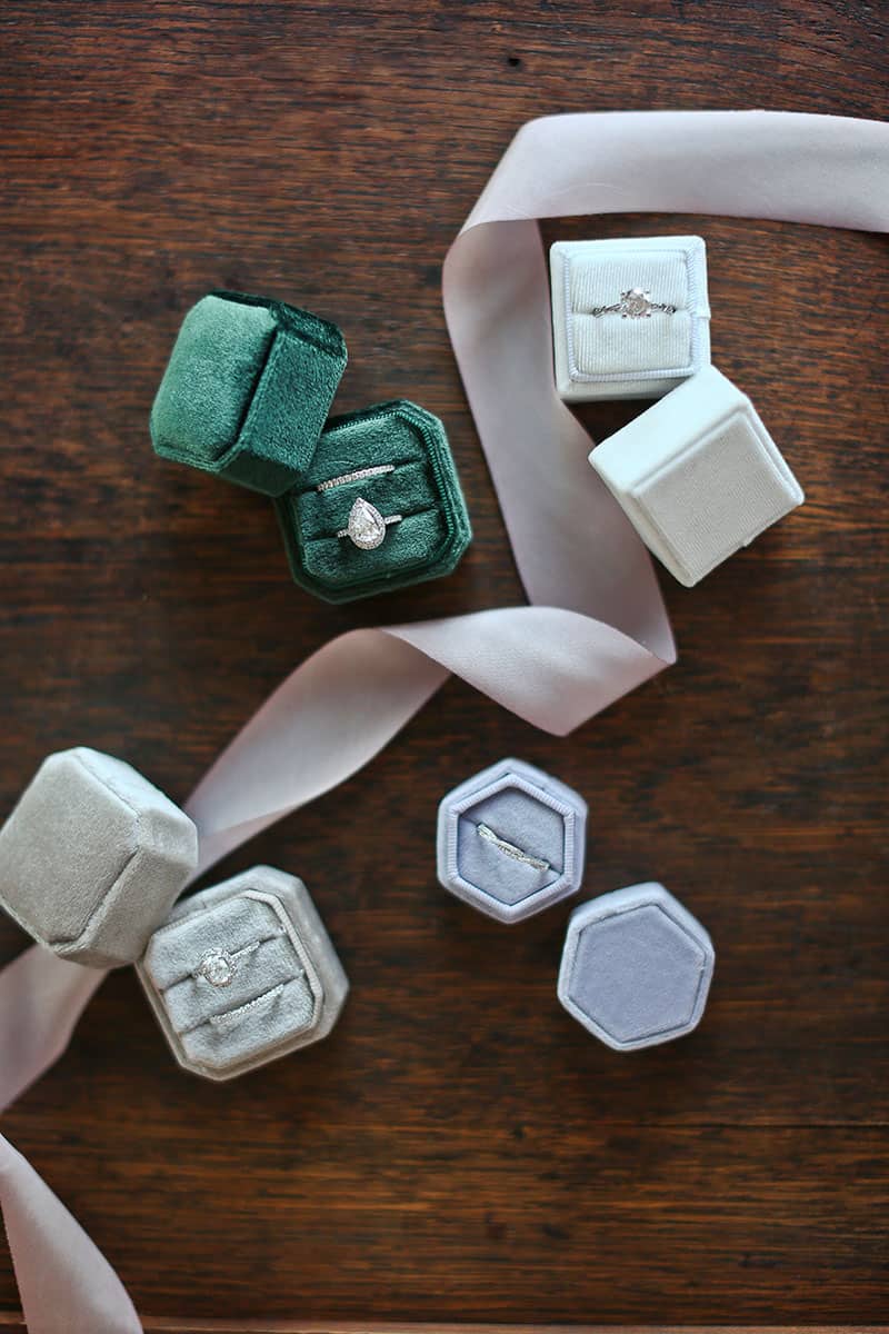 beautiful wedding band sets in velvet boxes displayed on wooden table