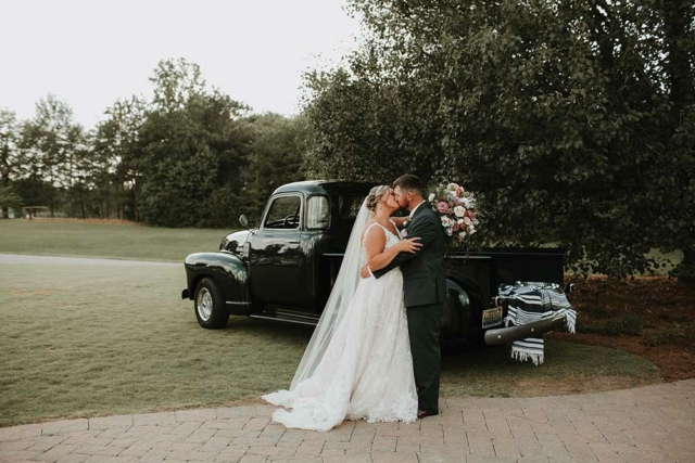 wedding couple kissing in front of emerald green vintage truck