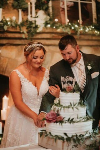 wedding couple cutting wedding cake smiling