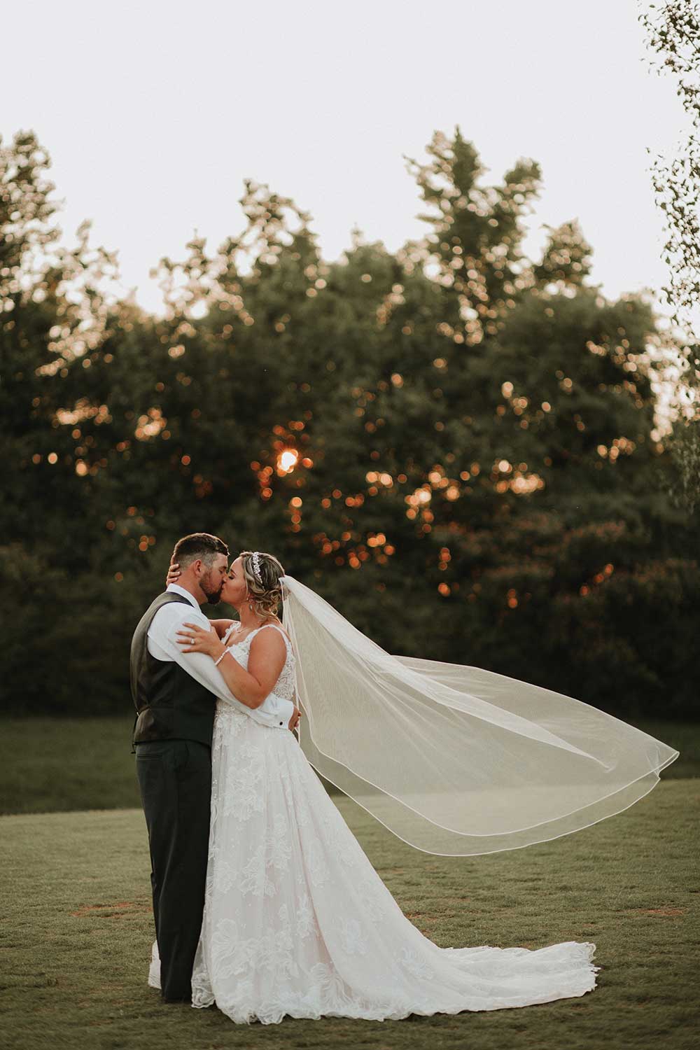 kissing wedding couple veil in the wind