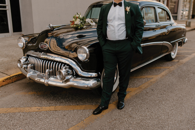 emerald green groom suit standing in front of vintage car