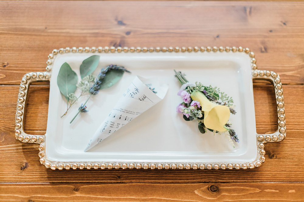 fresh flowers and lavender music note paper on gold tray