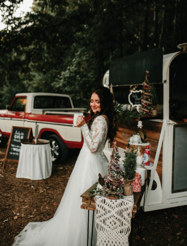 winter wedding beautiful bride drinking hot chocolate by vintage truck and trailer